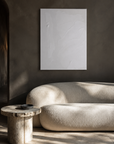 Space hung above a linen sofa in a warm plaster room