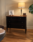 Theodore Alexander Atelier de Madeleine chest in black with cherry top, styled with a brass lamp and vintage books