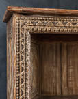 Close-up of the carved cornice and border with layered worn finish.