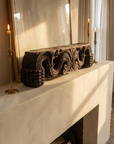Antique carved wood piece displayed on a fireplace mantel with candlesticks, showing its small scale