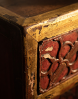Detail of the worn gilt edge meeting the carved red lacquer