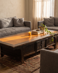 Antique low table in a living room with grey linen couches