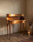 Vintage burl walnut bureau de dame writing desk in a warm plaster room, afternoon light
