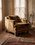 Three-quarter view of the bronze velvet club chair showing its low deep form