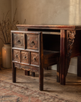 The carved chair pulled out from beneath the console table