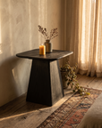 Ember Side Table, charred black Shou Sugi Ban wood, styled with candle and vessel in a warm plaster room