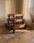 The three antique low tables stacked into a stepped tower