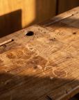 Macro of the desk top showing grain, ink marks, ring stains, and an inkwell hole