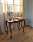 Vintage burl walnut side table in a soft blue-grey room by the window