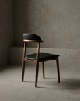 Three-quarter view of the walnut dining chair showing full silhouette and joinery