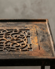 Macro detail of the Floral Scroll cast-iron grate and textured frame border
