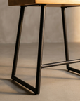 Macro detail of the Onda Stool blackened metal base and stretcher