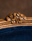 Detail of the two carved wooden flowers at the crest of the chair