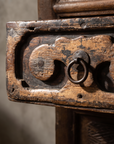 Macro detail of the carved cloud-bracket drawer pull with forged iron ring