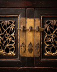 Detail of the center brass hasp, vase-shaped drop pulls, and pierced bamboo door panels