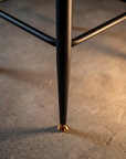 Alternate detail of the tapered black metal leg with brass glide