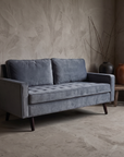 Dusk Velvet Track-Arm Loveseat against raw plaster wall