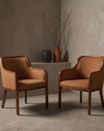 Burnt Orange Woven Armchairs against raw plaster wall
