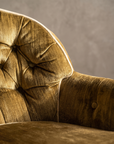 Detail of diamond button-tufted back, arm button, and cream welt piping