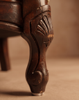 Detail of carved cabriole leg and wear on light sage velvet sofa
