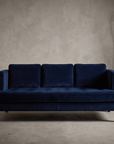 Shenandoah navy velvet track-arm sofa, hero shot in a greige plaster room