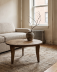 Antique round coffee table, darker, lifestyle hero in a small NYC apartment