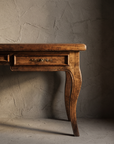 The Cabriole Writing Desk, macro detail of the center drawer pull, keyhole escutcheon, and cabriole leg