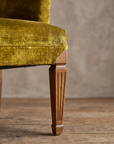 Macro detail of the square track arm and fluted tapered leg on the chartreuse velvet armchair, alternate angle
