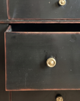 Close detail of the middle drawer pulled open, showing the drawer interior and brass knob