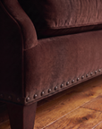 Detail of the tapered leg, self-tone herringbone braid, and fluted bronze nailhead trim on the Taylor King sofa