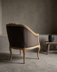 The Harvest, carved wheat motif bergere chair, back three-quarter view with smooth upholstered back