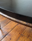 Close-up of the crackled bronze rim and black edge band of the oval coffee table