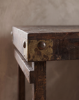 Close detail of a metal corner plate with round stud on the weathered wood apron