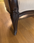 Close-up of the carved cabriole leg and front corner of the settee frame