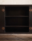 Detail of the open center shelves and aged bronze round door plates with leaf pulls