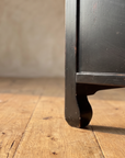 Close-up of the curled hoof foot on a reclaimed wood floor
