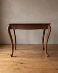 Front view of the oak writing desk showing the single drawer and scalloped apron