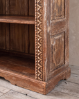 Close-up of the carved upright, side panel and scalloped plinth base.