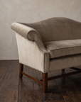 Detail of the sofa end, scroll arm curling over the bench cushion