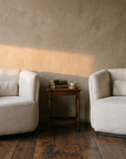 Pair of white armchairs with an antique side table, old books and a cup of tea in late afternoon light