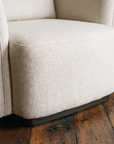 Close-up of the self-welt piping running down the armchair's rounded arm