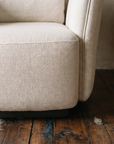 Close-up of oatmeal herringbone weave seat cushion and dark plinth base