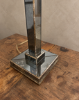 Close view of the lamp's stepped mirrored base and aged gold-toned edging