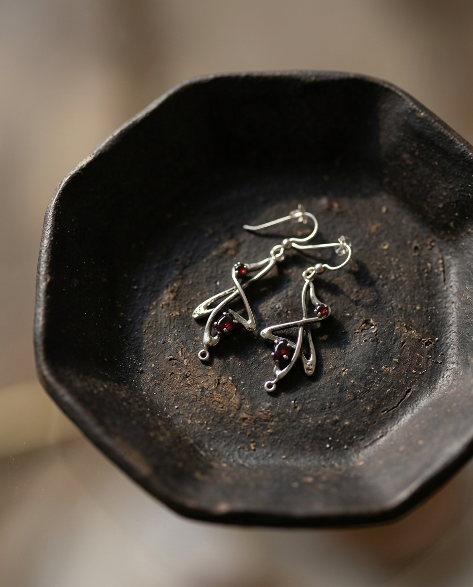 Garnet Whiplash Earrings on black ceramic dish