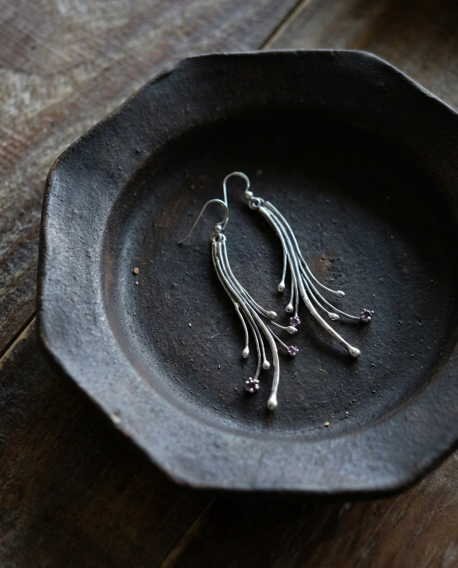 Amethyst Comet Earrings on black ceramic dish
