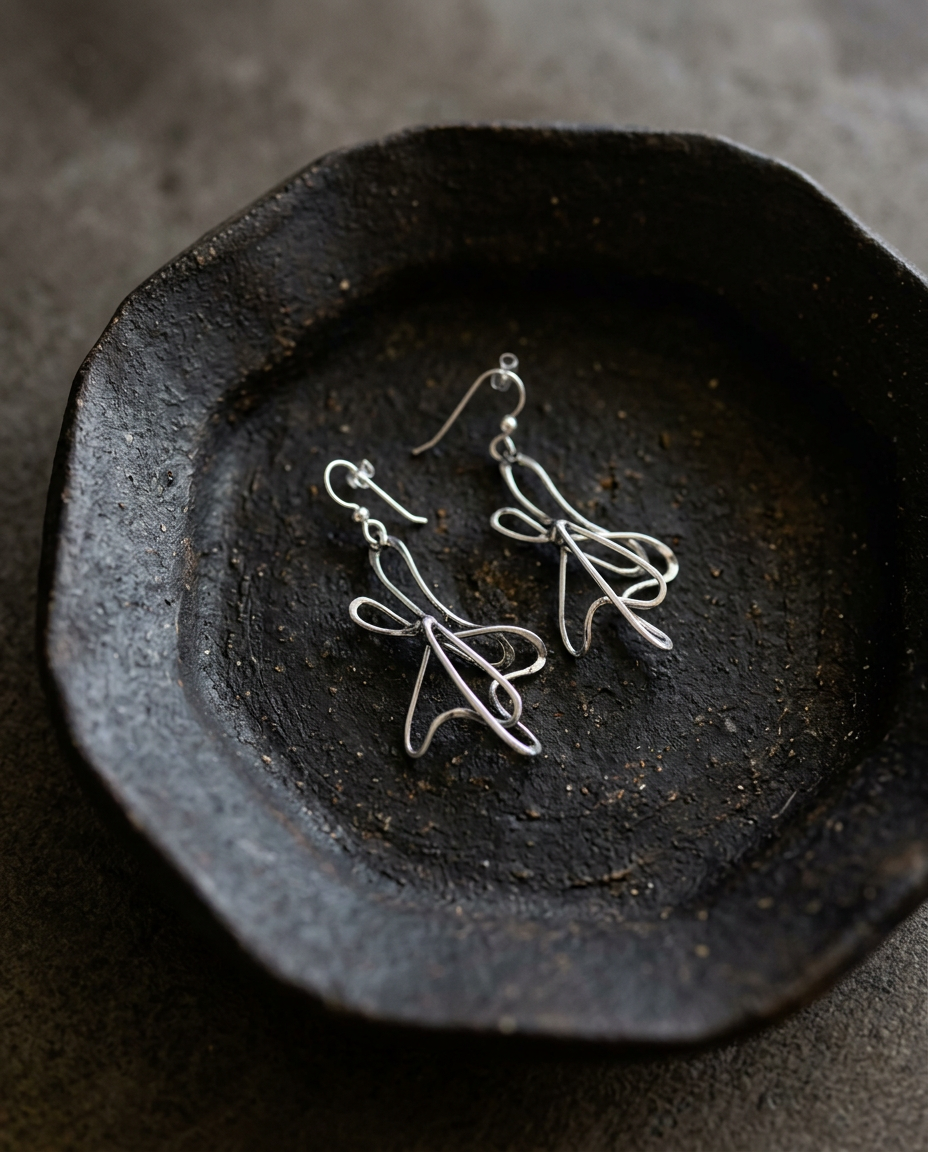 Silver Ribbon Earrings on black ceramic dish