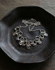 Silver Loop Statement Necklace on black ceramic dish