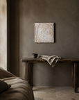 Sanctuary 4 hung above a weathered console in a warm plaster room