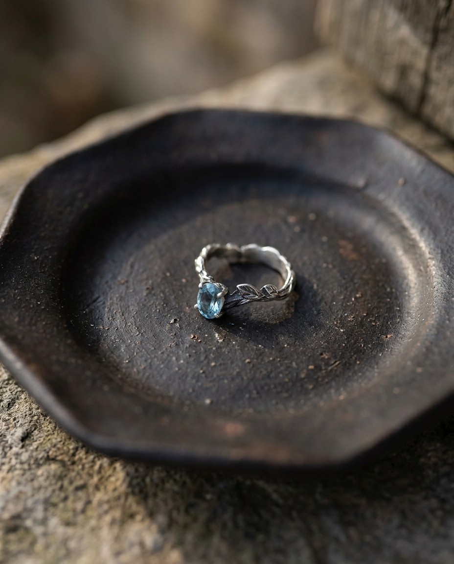 Blue Topaz Twig Ring on black ceramic dish