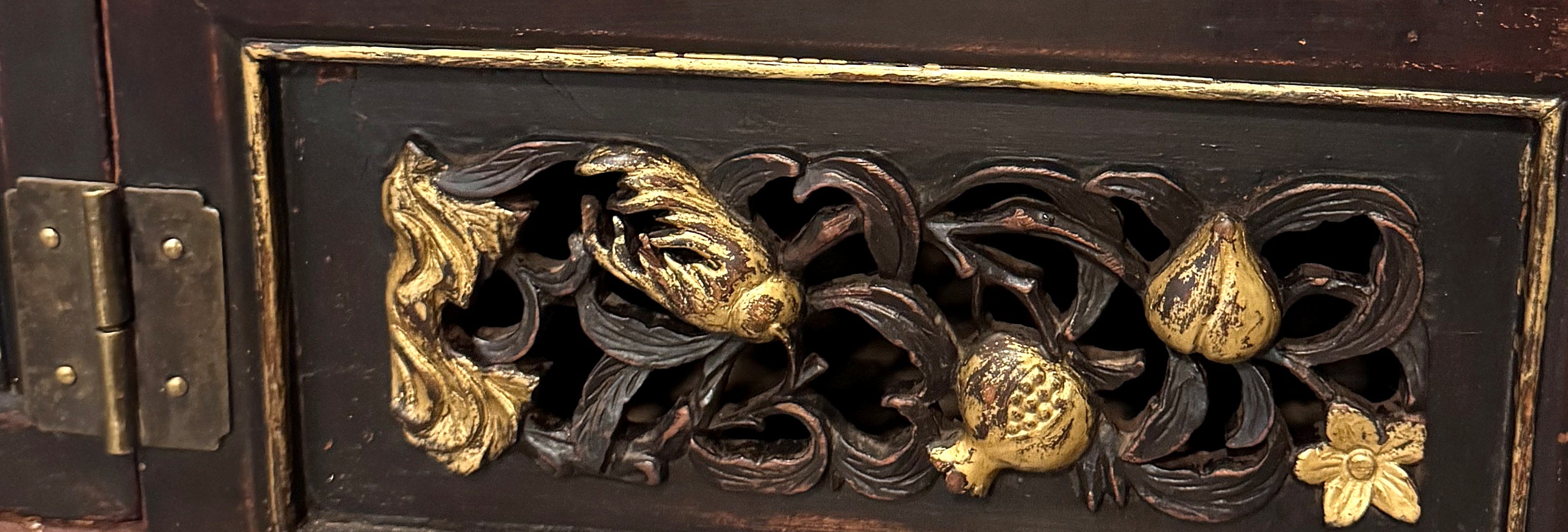 Detail of pierced gilt-highlighted peach, pomegranate and bird carving on the console drawer front